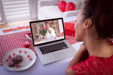 Sevgililer Günü videosu çeken çeşitli çiftler dizüstü bilgisayardaki adamı öperken arıyor. Karantina süresince çevrimiçi sevgililer günü iletişimi.