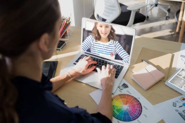 Beyaz kadın öğretmen, liseli kızla video görüşmesinde dizüstü bilgisayar kullanıyor. Çevrimiçi eğitim karantina süresince evde tek başına kalıyor..