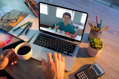 Erkek öğretmenle video görüşmesi sırasında beyaz öğrencilerin öğrenme yetenekleri dizüstü bilgisayarlarda sergilendi. Çevrimiçi eğitim karantina süresince evde tek başına kalıyor..