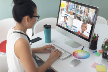 Beyaz kadın öğretmen evden öğrenen okul çocuklarıyla bilgisayar başında konuşuyor. Çevrimiçi eğitim karantina süresince evde tek başına kalıyor..