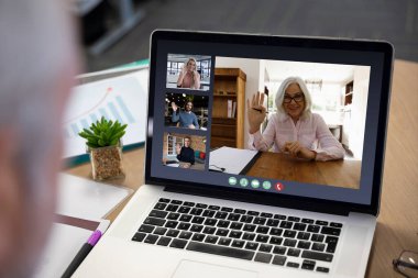 Ofisteki video görüşmesi sırasında çeşitli iş adamları dizüstü bilgisayarda görüntülendi. Covid 19 salgını sırasında sosyal mesafeli iletişim teknolojisi işyeri.