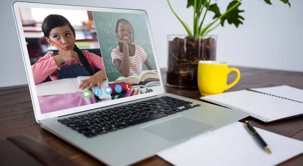 Laptop computer with a video call from diverse children lying on desk. work at a modern office.