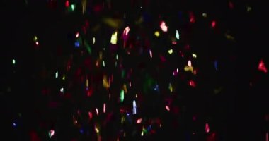 Siyah arka planda çok renkli konfeti düşüyor. Yılbaşı partisi şenlik kutlaması konsepti dijital olarak oluşturuldu.