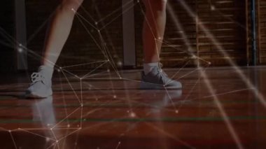 Arka planda kapalı bir sahada basketbol oynayan karışık ırktan bir kadının bağlantı ve veri paylaşım noktaları ağının animasyonu