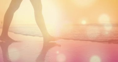 Sahilde yaz aylarında, arka planda hipnotik hareketlerle hareket eden birden fazla parıldayan ışık noktasıyla yürüyen kadın animasyonu. Tatil rahatlatıcı ve sakin konsept dijital olarak oluşturulmuş görüntü.