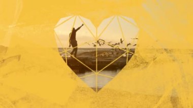 Gün batımında kollarını kumsalda sallayan bir adamın animasyonu. Gün batımında deniz üzerinde uçan bir kuş sürüsü. Ön planda sarı kalp şeklinde bir pencereden görülüyor.