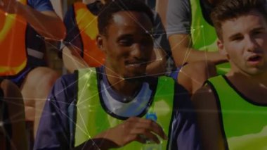 Koltuklarda oturan, su içen ve arka planda dinlenen bir spor takımının ön görüntüsüyle bağlantılı bir ağ animasyonu