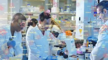 Covid-19 kelimelerinin ve hücre ikonlarının çok ırklı doktorların numuneleri kontrol etmesi üzerine animasyonu. Covid-19 Coronavirus salgını sırasında tıbbi personel.