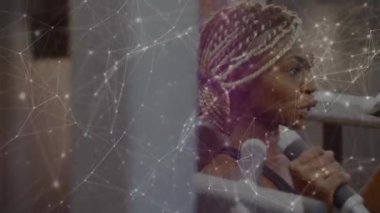 Bağlantılar ve veri paylaşımı ağının animasyonu, arka planda bir spor salonunda ekipmanla çalışan karışık ırktan bir kadınla