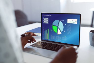 Afro-Amerikan iş kadınının elleri bilgisayardaki iş raporlarını analiz ediyor. Değiştirilmemiş, ofis, finans, veri, grafikler ve teknoloji kavramı.