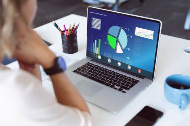 Beyaz kadın girişimci ofisteki laptopta iş raporlarını analiz ediyor. Değiştirilmemiş, grafikler, veriler, iş dünyası, finans, yatırım, ilerleme ve teknoloji kavramı.