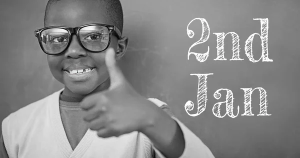 Composite of 2nd jan text and portrait of african american boy showing thumbs up, copy space. Childhood, education, eyeglasses, christmas, holiday and celebration concept.