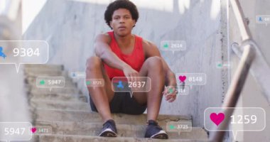 Afro-Amerikan bir adamın oturması üzerine medya simgelerinin canlandırılması. Küresel iş ve dijital arayüz kavramı dijital olarak oluşturulmuş video.