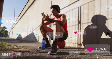 Akıllı telefon kullanan Afro-Amerikan bir adamın medya simgelerinin animasyonu. Küresel iş ve dijital arayüz kavramı dijital olarak oluşturulmuş video.