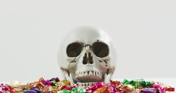 灰色の背景にお菓子を頭蓋骨の上にハロウィーンのテキストのイメージ ハロウィン お祭りの伝統とお祝いのコンセプトデジタル生成されたイメージ — ストック写真