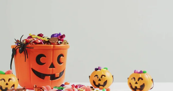 Obraz Halloween Tekst Nad Rzeźbione Wiadro Dyni Słodyczami Szarym Tle — Zdjęcie stockowe