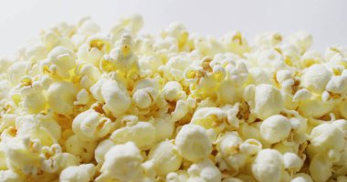 Beyaz arka plana düşen patlamış mısırın yakın plan görüntüsü. Yiyecek, parti ve fotokopi alanı.