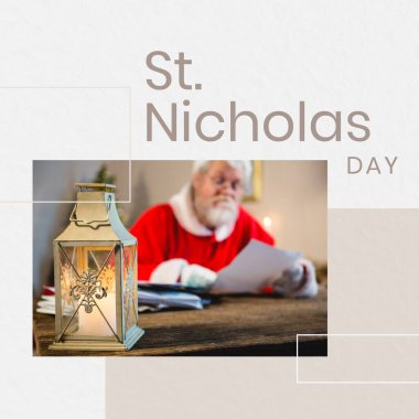 Masasında lamba, Noel Baba kostümü giymiş beyaz bir adam mektup okuyor ve Aziz Nicholas Günü mesajı yazıyor. Birleşim, kopyalama alanı, ziyafet, Hıristiyanlık, gelenek ve kutlama konsepti.