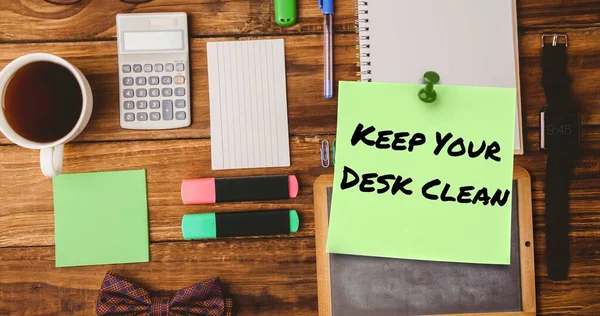 Keep your desk clean text on sticky note with various office supplies and coffee on table. Office, unaltered, stationery, drink, hygiene, awareness, celebration and technology concept.