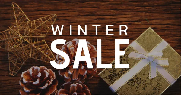 Composition of winter sale text over christmas decoration in background. Christmas, sales, tradition, celebration and festivity concept digitally generated image.