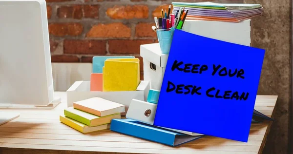 Composite of keep your desk clean on sticky note with office supplies and desktop on table. Office, stationery, hygiene, awareness, celebration and technology concept.