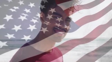 Sahilde gülümseyen melez bir adam için Amerika Birleşik Devletleri bayrağının animasyonu. Amerikan vatanseverliği, çeşitlilik ve gelenek konsepti dijital olarak oluşturulmuş video.