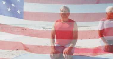 Amerika Birleşik Devletleri bayrağının sahilde meditasyon yapan yaşlı çiftler üzerinde canlandırılması. Amerikan vatanseverliği, çeşitlilik ve gelenek konsepti dijital olarak oluşturulmuş video.