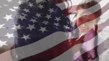 Amerika Birleşik Devletleri bayrağının animajı, kumsalda kızı olan melez bir anne yerine. Amerikan vatanseverliği, çeşitlilik ve gelenek konsepti dijital olarak oluşturulmuş video.