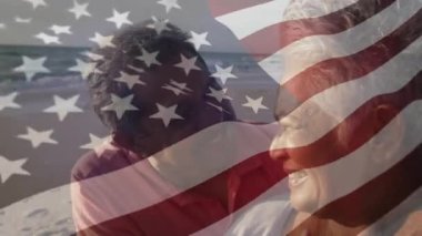 Amerika Birleşik Devletleri bayrağının sahildeki üst düzey melez çift üzerinde canlandırılması. Amerikan vatanseverliği, çeşitlilik ve gelenek konsepti dijital olarak oluşturulmuş video.