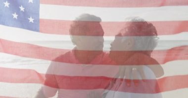 Amerika Birleşik Devletleri bayrağının animasyonu sahilde öpüşen yaşlı çiftler üzerine. Amerikan vatanseverliği, çeşitlilik ve gelenek konsepti dijital olarak oluşturulmuş video.