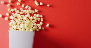 Kırmızı arkaplanda patlamış mısır resmi. Yiyecek, parti ve fotokopi alanı.