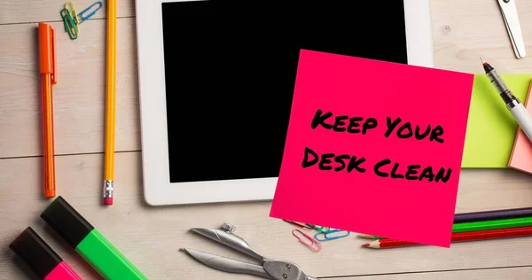Composite of keep your desk clean text on sticky note with digital tablet and stationery on table. Office, office supplies, desk, hygiene, awareness, celebration and technology concept.