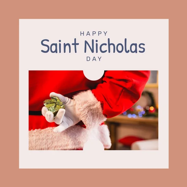 Composition of saint nicholas day text over santa claus holding present. Saint nicholas day, christmas festivity, tradition and celebration concept.