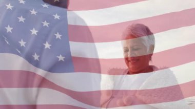 Amerika Birleşik Devletleri bayrağı ve plajdaki üst düzey melez çiftin animasyonu. Amerikan vatanseverliği, çeşitlilik ve gelenek konsepti dijital olarak oluşturulmuş video.