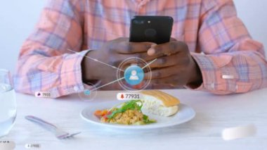 Akıllı telefon kullanan Afro-Amerikan bir adam üzerinde ikonlarla iletişim ağı animasyonu. Küresel bağlantılar ve dijital arayüz konsepti dijital olarak oluşturulmuş video.