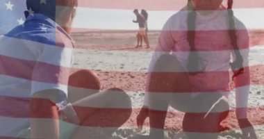Amerika Birleşik Devletleri bayrağının deniz kenarında çocuklu melez çiftler üzerinde canlandırılması. Amerikan vatanseverliği, çeşitlilik ve gelenek konsepti dijital olarak oluşturulmuş video.