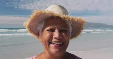 Mutlu noeller ve yeni yıl mesajlarının animasyonu güneşli plajda mutlu çift ırklı yaşlı kadın üzerine. Noel, tatiller, şenlik, yeni yıl ve dijital olarak üretilen kutlama konsepti.