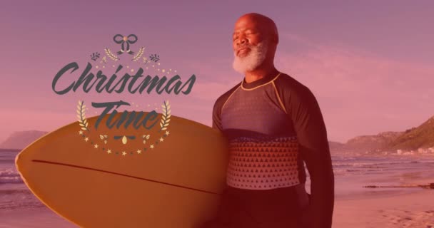 Animación Texto Navideño Sobre Feliz Hombre Afroamericano Mayor Con Tabla — Vídeo de stock