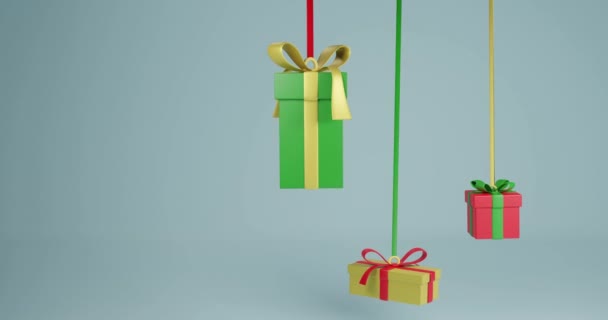 3つのクリスマスプレゼントのビデオは グレーの背景にコピースペースのリボンでぶら下がっています クリスマス お祭り お祝いのコンセプト — ストック動画