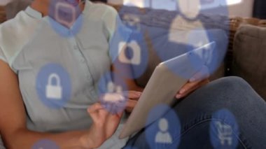 Tablet kullanan beyaz kadın üzerinde medya simgelerinin canlandırılması. Sosyal medya ve dijital arayüz konsepti dijital olarak oluşturulmuş video.