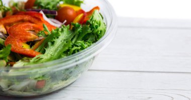 Cam kâse içinde taze sebze salatası, ahşap masa üzerinde fotokopi alanı. Vejetaryenlik, organik gıda, sağlıklı, destek, vegan günü ve kutlama konsepti.