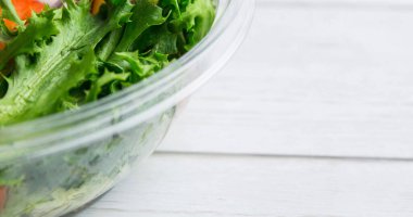 Yüksek açılı taze sebze salatası cam kasede, ahşap masanın üzerinde, kopyalama alanı. Değiştirilmemiş, veganlık, organik, yiyecek, sağlıklı, destek, vegan günü ve kutlama konsepti.