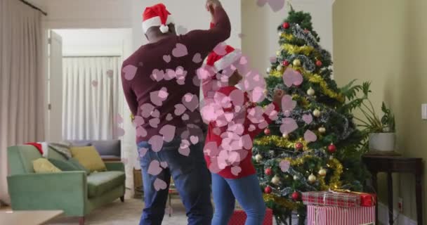 Анімація Рожевих Сердець Над Старшою Афроамериканською Парою Капелюхах Санти Танцює — стокове відео