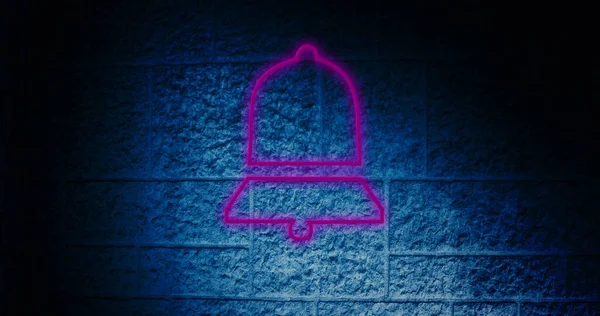 Composite of illuminated digital pink notification bell icon against blue wall, copy space. Dark, social media, information, reminder, symbol and technology concept.