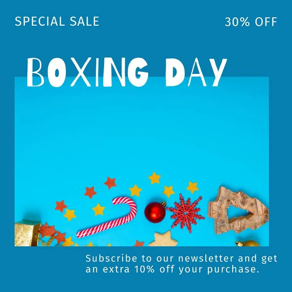 Composition of boxing day sales text over christmas decorations on blue background. Christmas, boxing day, sales, festivity, celebration and tradition concept digitally.