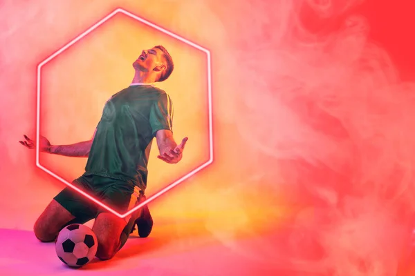 白种人男性球员 手臂伸展 跪在发光的六边形上 背靠霓虹灯背景 复制空间 数字合成 吸烟和抽象 — 图库照片