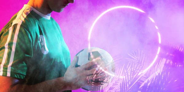 中段的高加索男子球员拿着球在灯火通明的圆形和植物之上 复制空间 数码合成 霓虹灯 发光和抽象的概念 — 图库照片