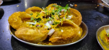Tabağına nohut doldurulmuş baharatlı Pani puri. Ünlü Hint Atıştırmalıkları Resimleri.