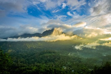 Güneşin doğuşu ve geçen bulutlarla güzel bir dağ manzarası. Munnar, Kerala, Hindistan