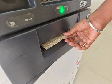 ATM 'den para çekme - ATM' de Hint rupileri. Adam ATM, otomatik vezne makinesi konseptiyle para çekiyor.